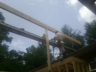 Carpenter setting a ridge beam over a new addition frame — Ice Dam Removal by Roofing Brothers in Rocky Ford