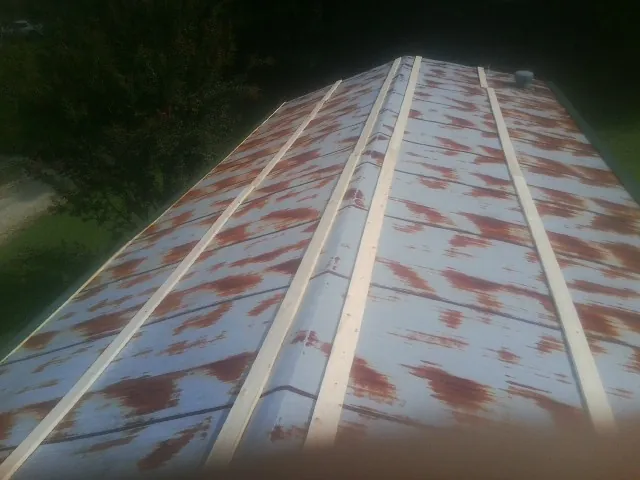 Rusted metal roof panels with new wood purlins before replacement — Storm Damage Roof Repair in Rocky Ford by Roofing Brothers