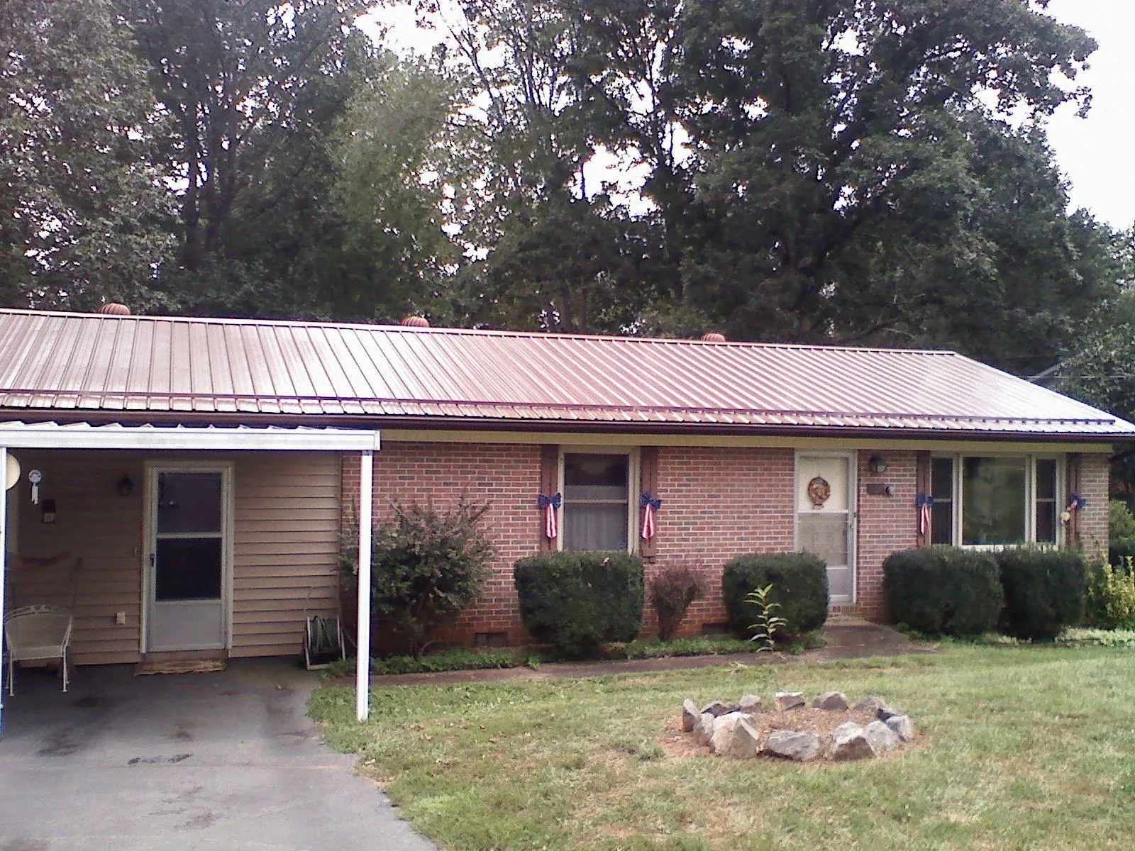 Bronze metal roof and carport on a brick ranch home — Roof Repair work by our crew in Rocky Ford