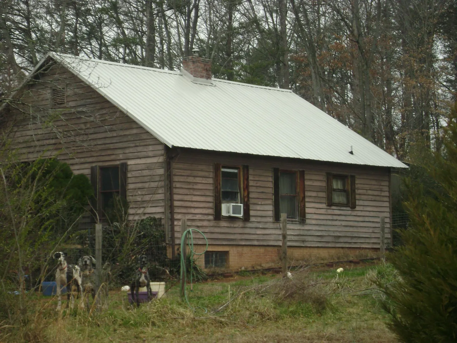 White metal roof on an old wood sided farmhouse, from a Metal Roof Installation job in Rocky Ford